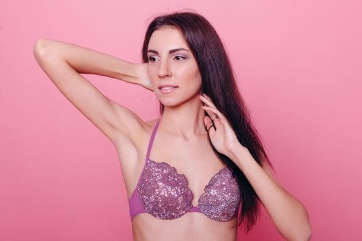 Adorable brunette in bikini posing on pink background photo