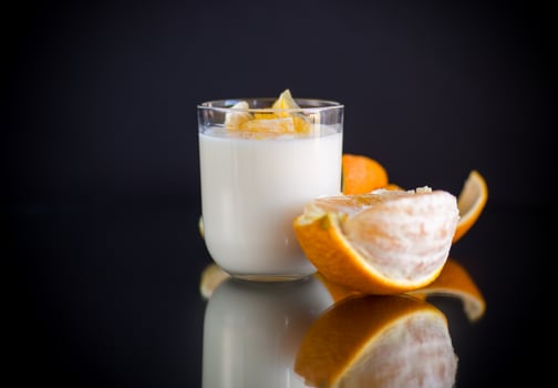 homemade sweet yogurt in a glass with oranges photo