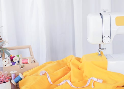 Close up of sewing machine working with yellow fabric,  stitch new clothing. photo