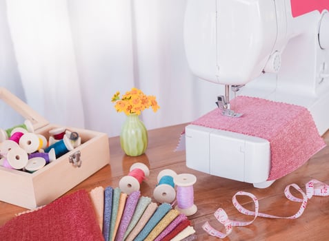 Close up of sewing machine working with red fabric,  stitch new clothing. photo