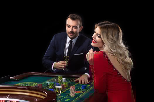 A beautiful young woman and a man are sitting at a roulette table. Casino. photo