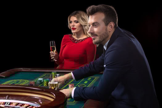 A beautiful young woman and a man are sitting at a roulette table. Casino. photo