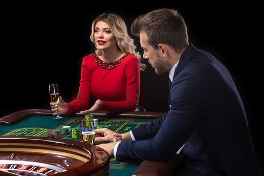 A beautiful young woman and a man are sitting at a roulette table. Casino. photo