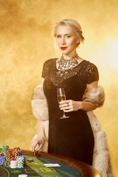 Portrait of woman keeping poker chips near table in casino photo