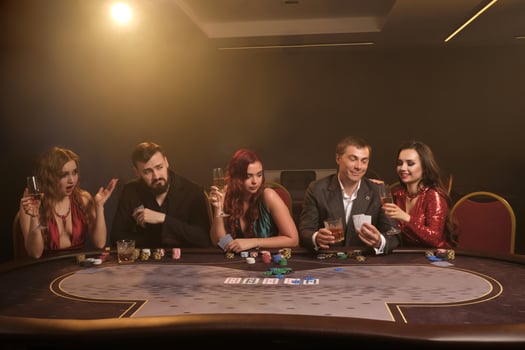 Group of a young rich friends are playing poker in casino. photo