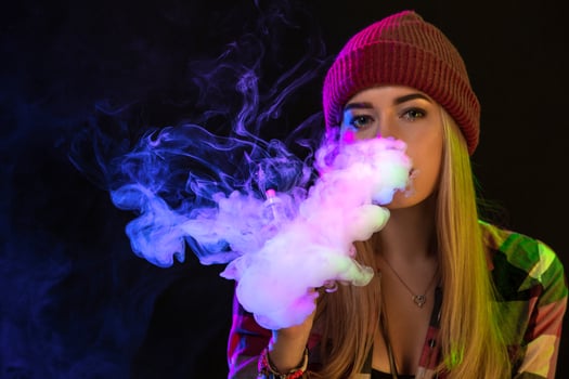 Vaping girl. Young hipster woman vape e-cig on studio on black background. Hip-hop style. Close up. photo