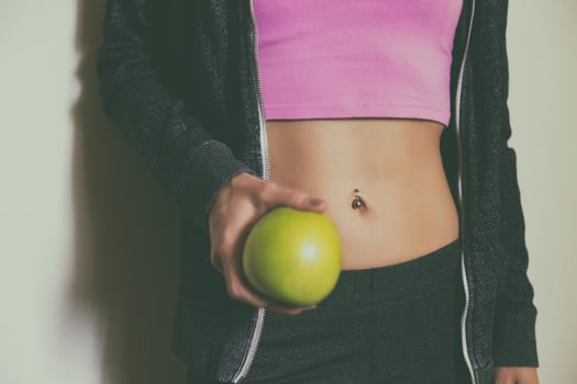 Fit sporty woman with abs holding apple.Toned photo. photo