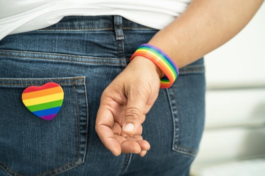 Woman holding LGBT rainbow colorful flag, symbol of lesbian, gay, bisexual, transgender, human rights, tolerance and peace. photo