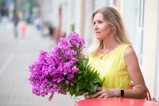 Beautiful elderly blonde woman with a huge bouquet of flowers. photo