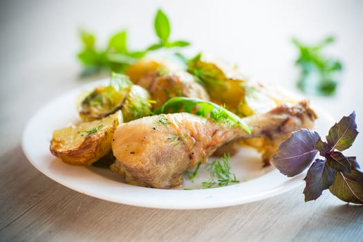baked chicken leg with early potatoes and zucchini photo