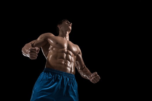 Muscular and fit young bodybuilder fitness male model posing over black background. photo