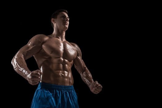 Muscular and fit young bodybuilder fitness male model posing over black background. photo