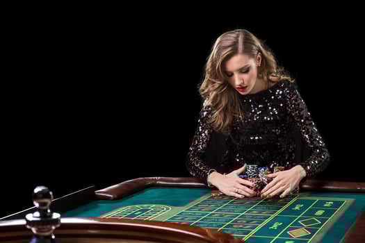 Woman playing in casino. Woman stakes piles of chips playing rou photo