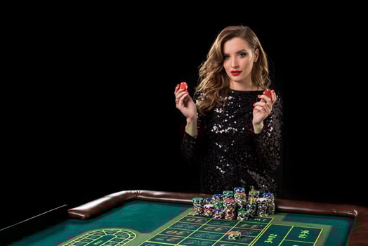 Woman playing in casino. Woman stakes piles of chips playing rou photo