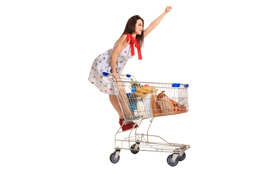 Woman with shopping cart full with products isolated over white background photo