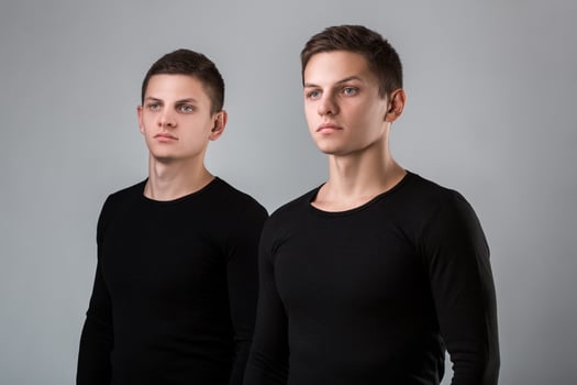 The two twin brother stand on the gray background photo