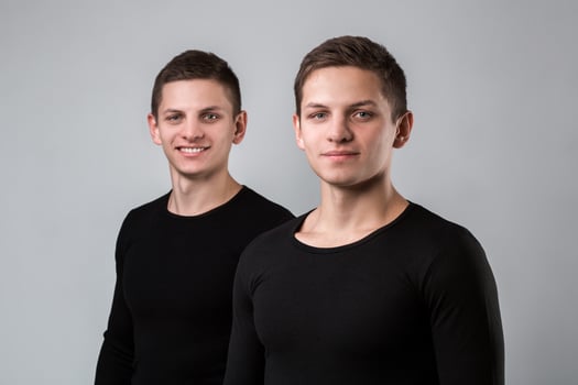 The two twin brother stand on the gray background photo