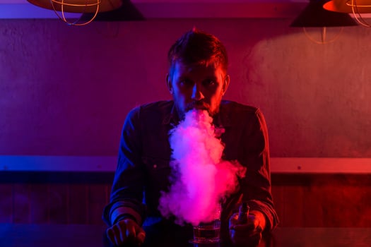 The man smoke an electronic cigarette at the vape shop. photo