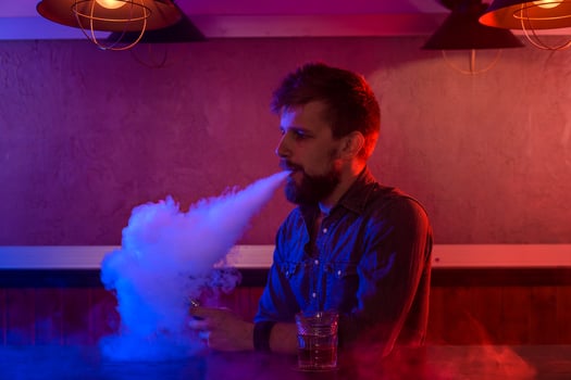 The man smoke an electronic cigarette at the vape shop. photo