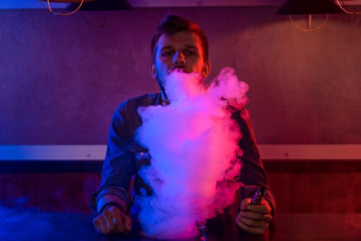 The man smoke an electronic cigarette at the vape shop. photo