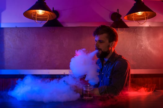 The man smoke an electronic cigarette at the vape shop. photo