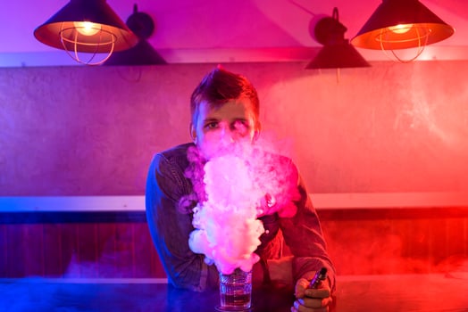 The man smoke an electronic cigarette at the vape shop. photo