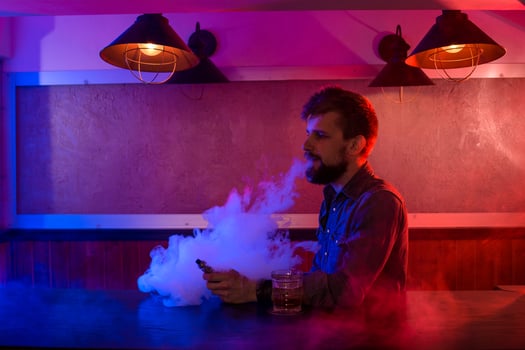 The man smoke an electronic cigarette at the vape shop. photo