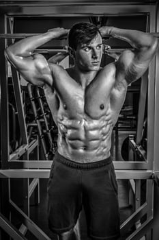 Handsome man with big muscles, posing at the camera in the gym photo