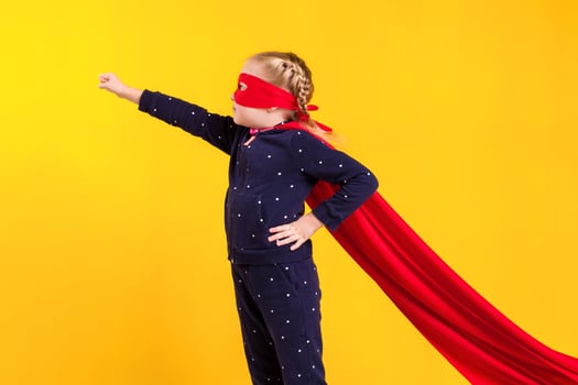 Superhero little girl in a red raincoat and a mask photo