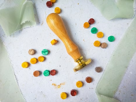 Vintage wooden wax seal stamp and colorful wax bead on a white background. photo