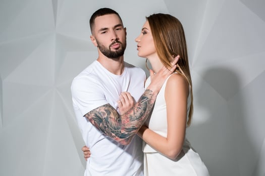 Portrait of a beautiful young couple in love posing at studio over white background. photo