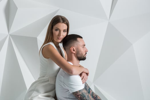 Portrait of a beautiful young couple in love posing at studio over white background. photo