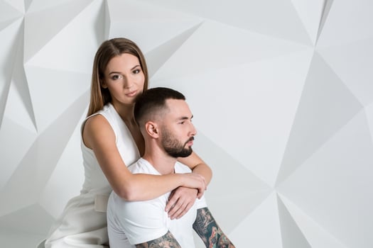 Portrait of a beautiful young couple in love posing at studio over white background. photo