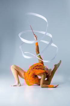 beautiful Caucasian girl gymnast with white ribbon photo