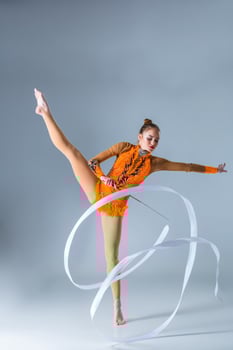 beautiful Caucasian girl gymnast with white ribbon photo