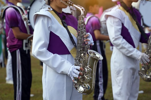 Orchestra students play saxophones in a parade at the school's athletics event. Soft and selective focus. photo