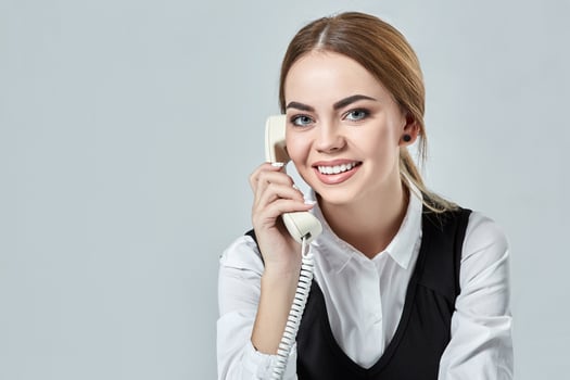 portrait of young secretary answering telephone photo