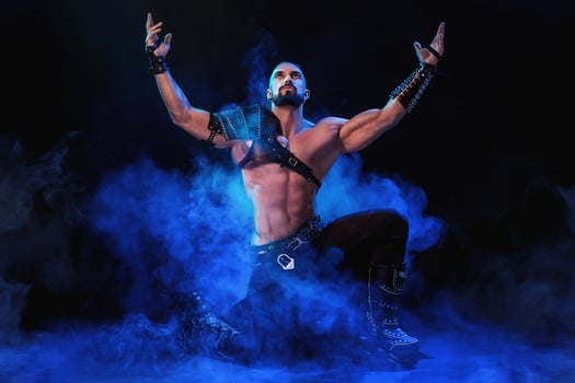 Handsome young sexy man with beautiful muscular chest in interesting costume on the scene photo