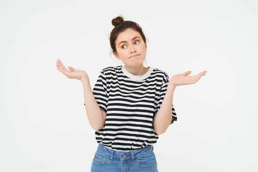 Image of confused brunette girl shrugging shoulders, looks puzzled, isolated over white background photo