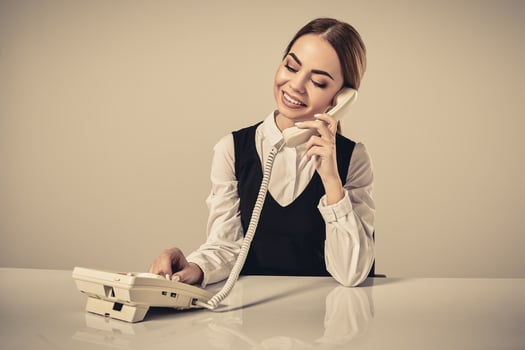 portrait of young secretary answering telephone photo