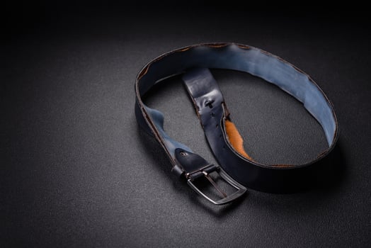 Old leather men's belt with an old-style metal buckle photo