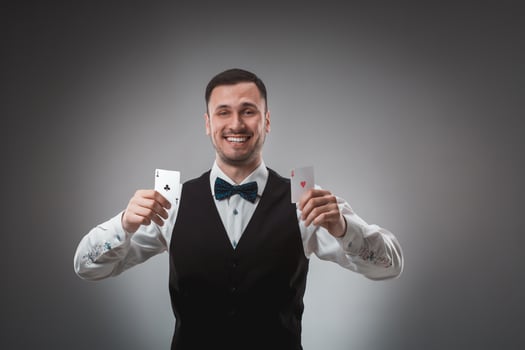 Young man in shirt and waistcoat shows his poker cards, studio shot photo