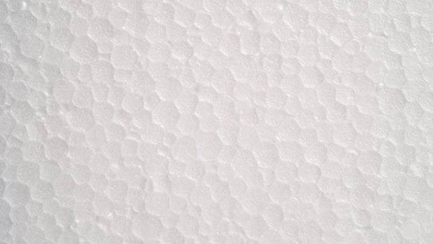 White foam sheet top view. Small and large clear foam beads, polystyrene sheet surface in closeup, close-up seamless background photo