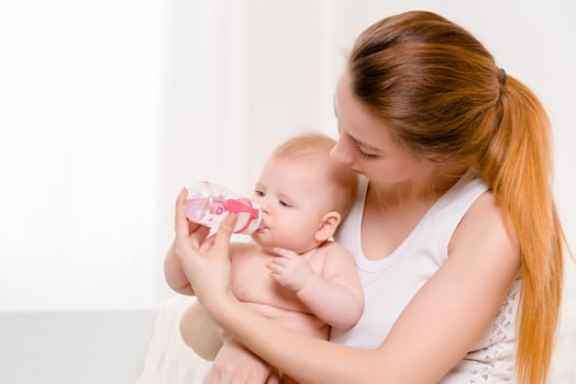 Feeding Baby. Baby eating milk from the bottle. photo