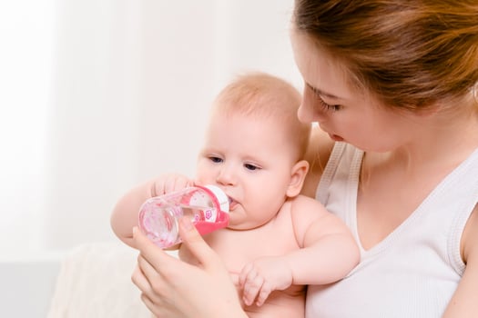 Feeding Baby. Baby eating milk from the bottle. photo