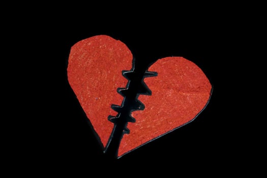 Red broken heart on dark background photo