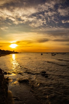 Beautiful sunset with silhouettes of people and fishing boats on the beach photo