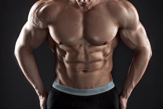 Muscular bodybuilder guy doing posing over black background photo
