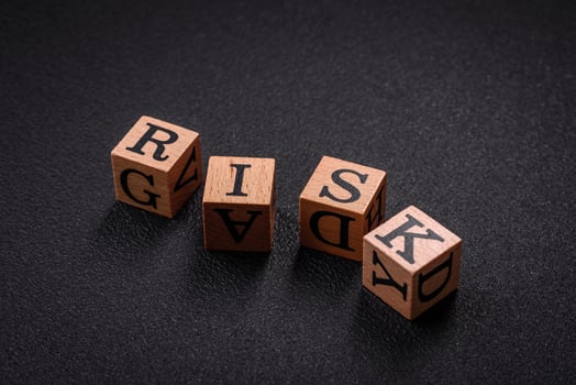 The inscription risk with wooden cubes on a dark concrete background photo