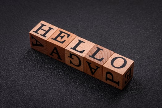 The inscription hello on wooden cubes on a dark concrete background photo